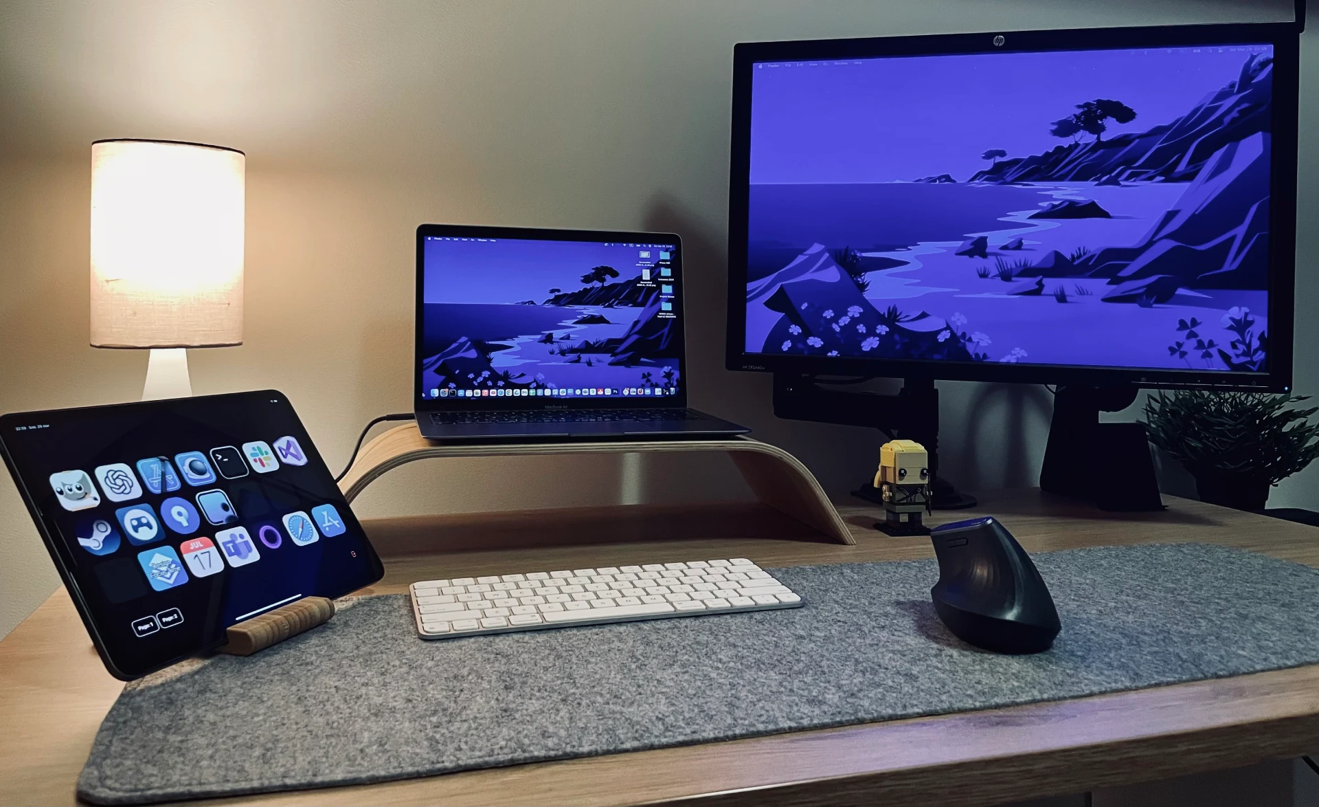 A real MacMobility setup: an iPad control panel beside a MacBook, monitor, and keyboard on a desk